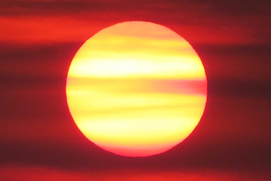 Smokey yellow sun on deep red background