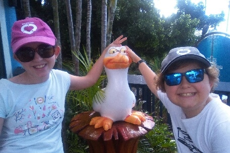 Jessica Rice and Sean Rice pose with a pelican statue