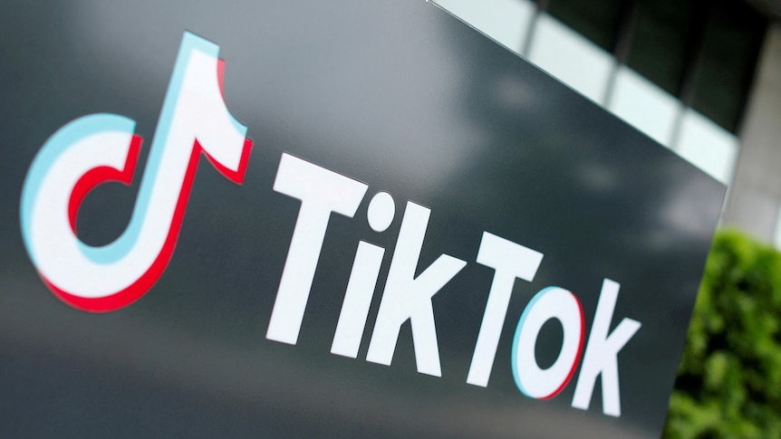 The TikTok musical note logo is displayed in white on a black wall.