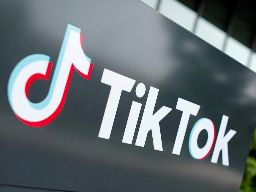 The TikTok musical note logo is displayed in white on a black wall.