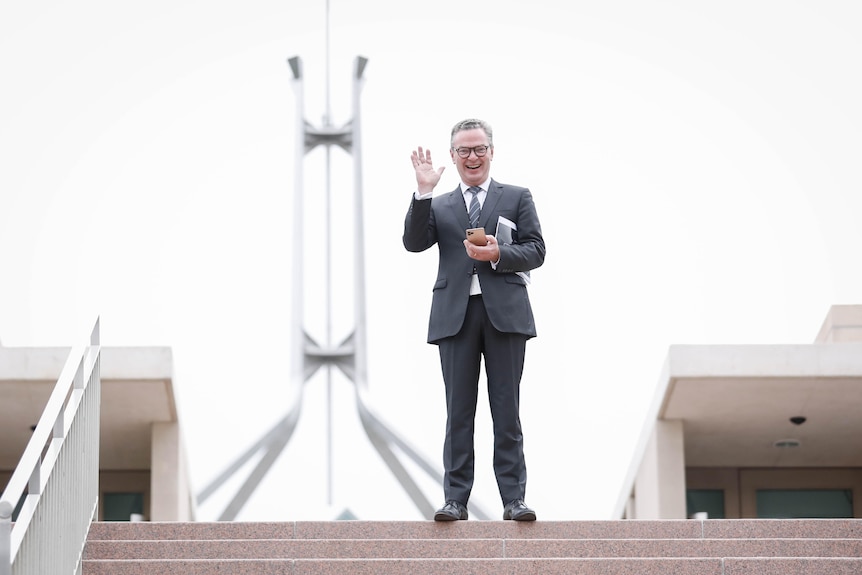 Christopher Pyne smiles and waves for the camera outside Parliament House