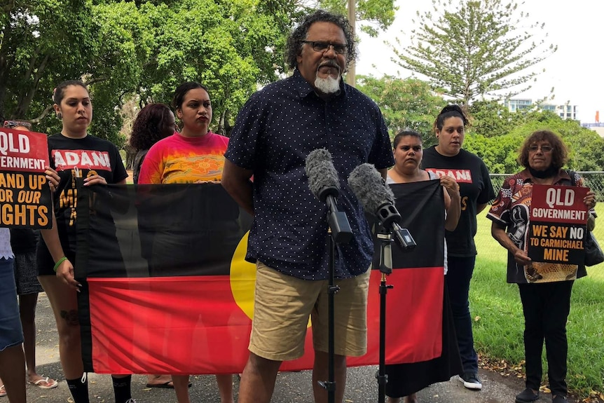 Adrian Burragubba from the W&J traditional owners holding a media conference, flanked by other W&J members