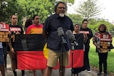 Adrian Burragubba from the W&J traditional owners holding a media conference, flanked by other W&J members