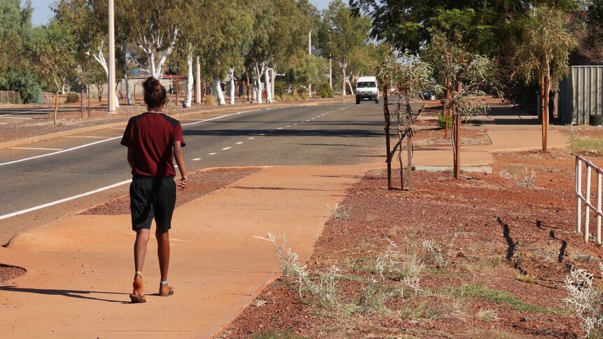 An Aboriginal woman walks down a street in Roebourne in the WA Pilbara.