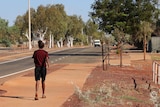 An Aboriginal woman walks down a street in Roebourne in the WA Pilbara.