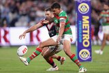 A Souths NRL player tries to shield a Roosters player from the ball in the in-goal.