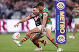 A Souths NRL player tries to shield a Roosters player from the ball in the in-goal.