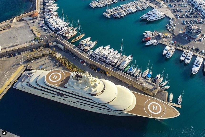 A superyacht, with two helipads, is seen from above docked at port