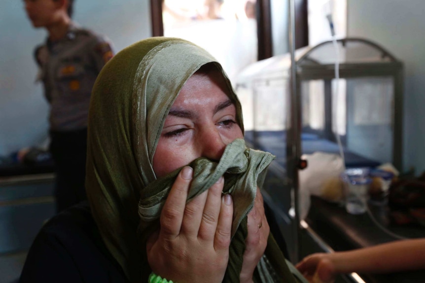 Nadine Bakour, a Lebanese woman who lost her husband and two sons in an boat accident off Java, cries in a health clinic.