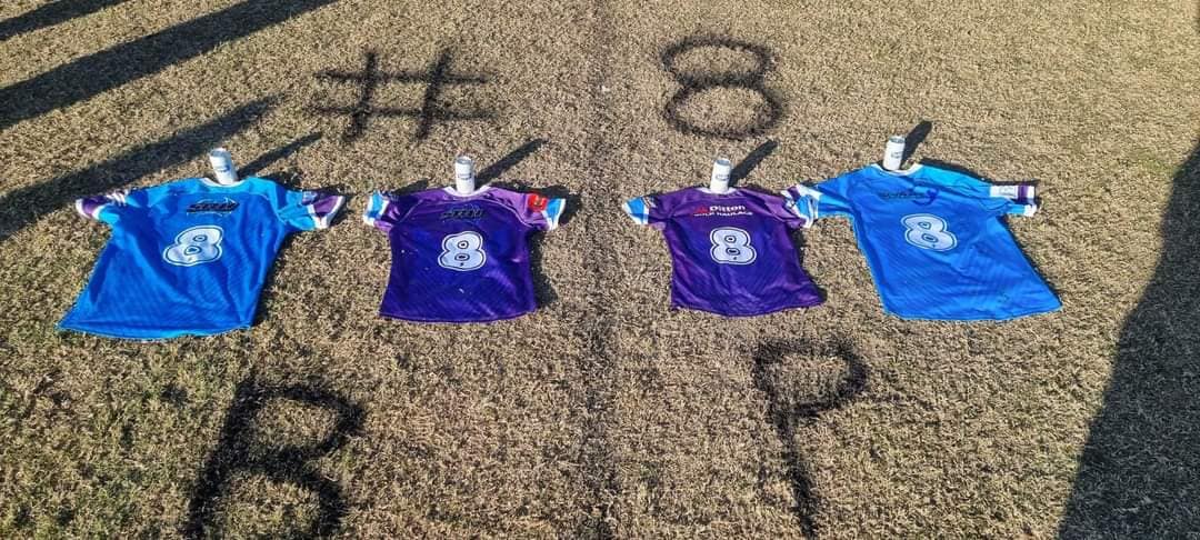 Four Aberglasslyn Ants rugby league jerseys, each bearing a number eight, lie on the grass.