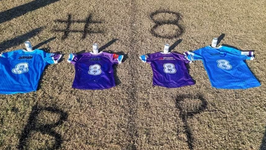 Four Aberglasslyn Ants rugby league jerseys, each bearing a number eight, lie on the grass.