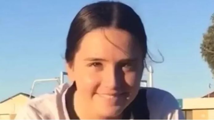 Girl with brown hair smiling at camera