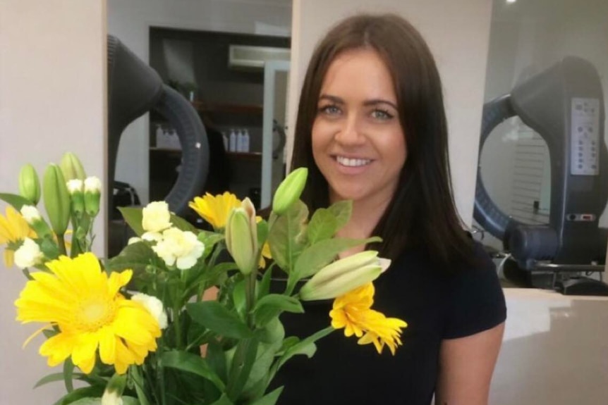 woman stands in salon with yellow flowers