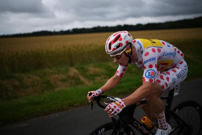 Jonas Abrahamsen rides his bike in the polka dot jersey