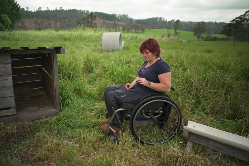 Image of a woman in a wheelchair on a rural property. 