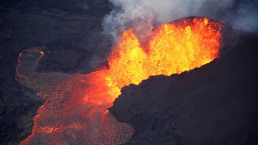 Lava erupts from a crater and flows away.