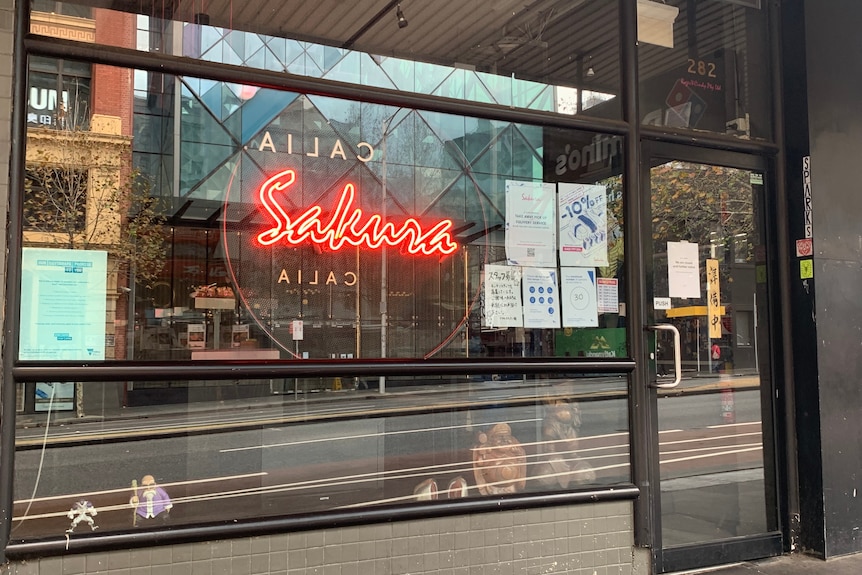 A red light in a restaurant window reads 'Sakura'.
