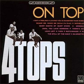 The band members sitting on top of large letters spelling 4 Tops