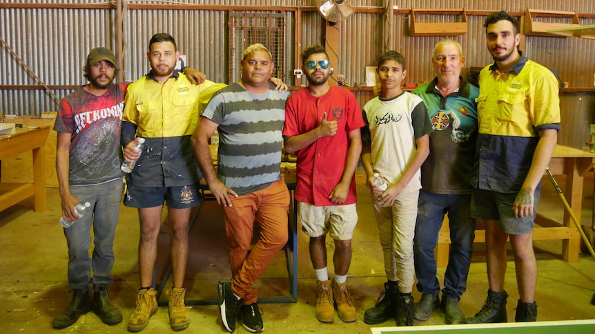 TAFE students with mentor and teacher in their work shed