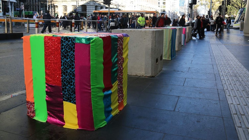 Colourful striped material covers a bollard at Southern Cross Station.