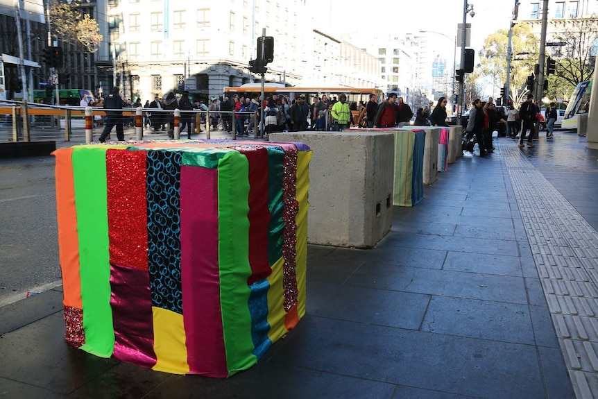 Colourful striped material covers a bollard at Southern Cross Station.