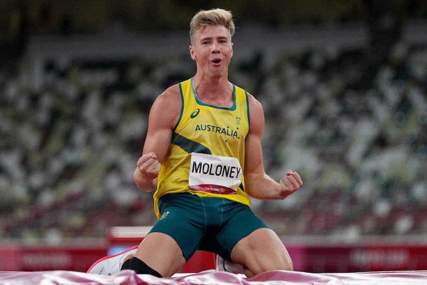Ashley Moloney pumps his fists while on his knees after completing a decathlon high jump.