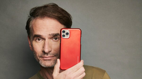 man in green tshirt holding a red mobile phone