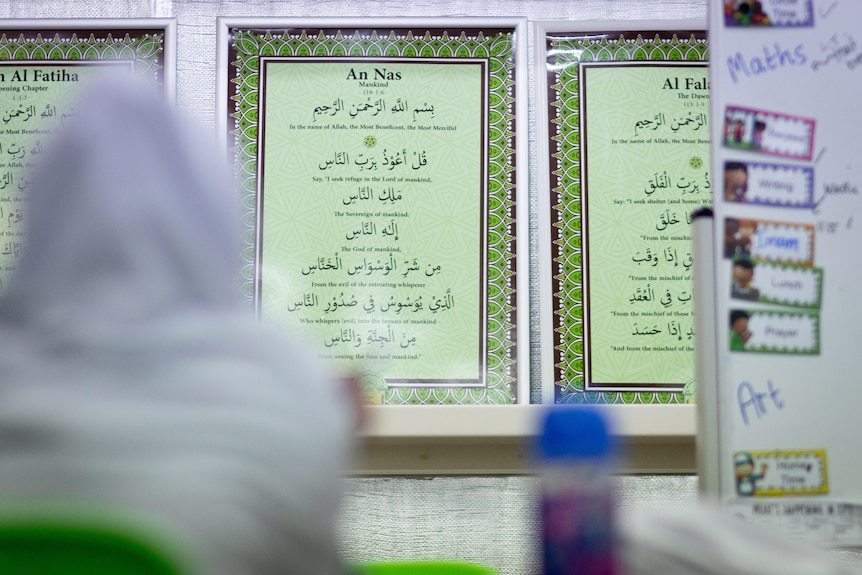 Verses from the Qur'an can be seen on the wall of a classroom. 