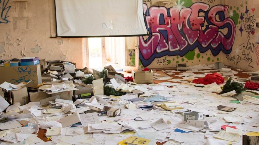 Room at the abandoned former NSW Health facility with documents strewn on floor