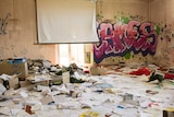 Room at the abandoned former NSW Health facility with documents strewn on floor