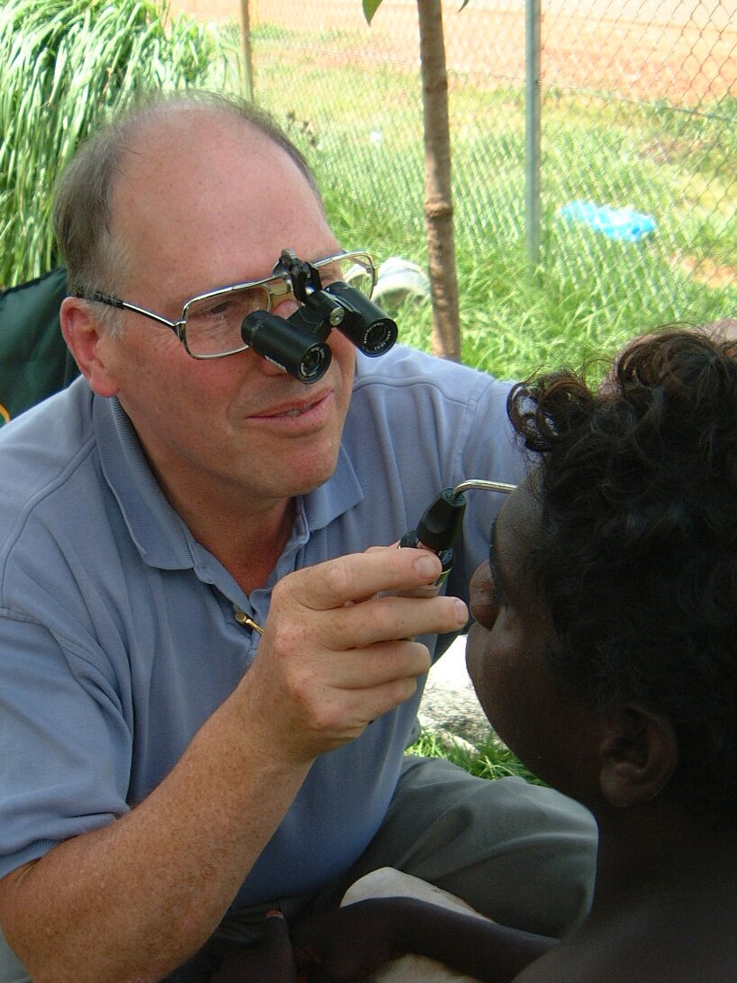 Hugh Taylor examines the eyes of an Aboriginal boy.