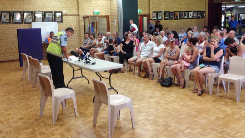 Around 40 people sit on chairs at a meeting about the Uduc bushfire.