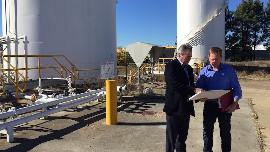 The two men examine plans for the site.