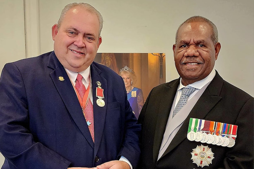 Justin Tkatchenko with PNG's governor general Sir Bob Bofeng Dadae in formal suits. 