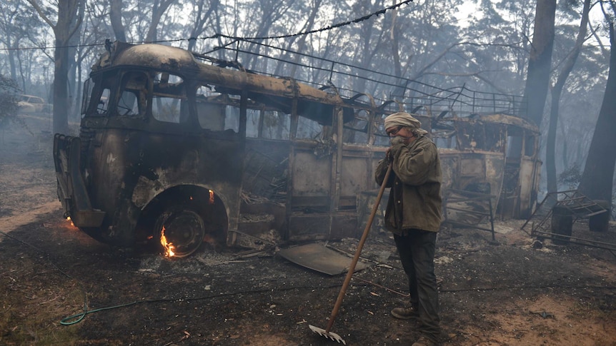 Resident Sean Butler stands in front of his 1958 bus after fighting a fire