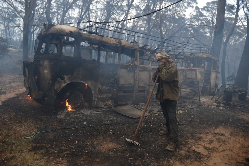 Resident Sean Butler stands in front of his 1958 bus after fighting a fire