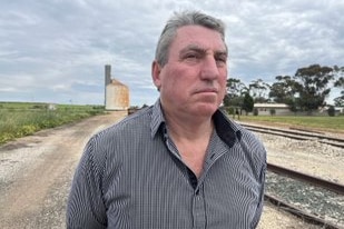 Reid Mather stands along a train line outside of Swan Hill in regional Victoria