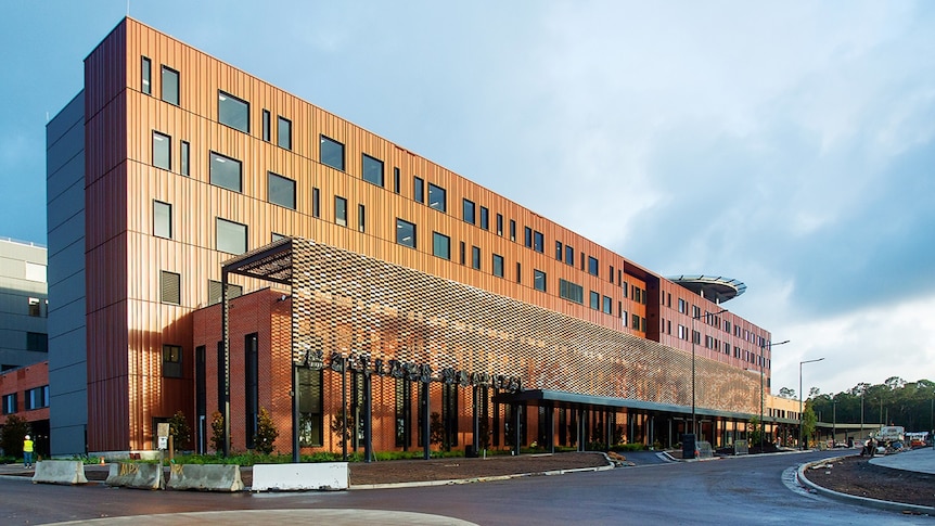 A large multi-storey hospital building with a copper-coloured exterior.