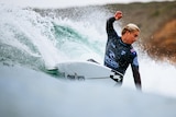 Ethan Ewing surfs a wave