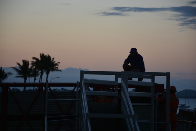 A worker takes a time out after loading cattle for live export at the Port of Townsville, north Queensland.