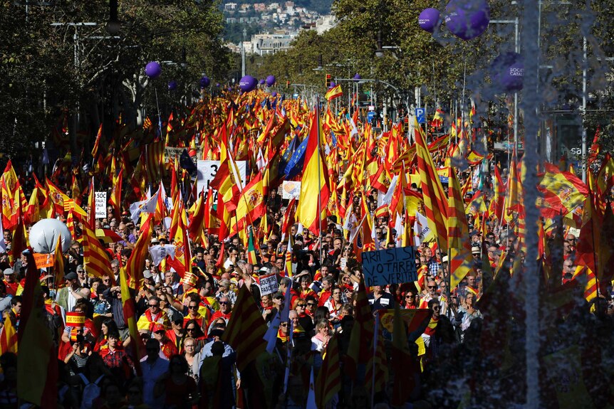 Nationalist activists march with Catalan, Spanish and European Union flags.