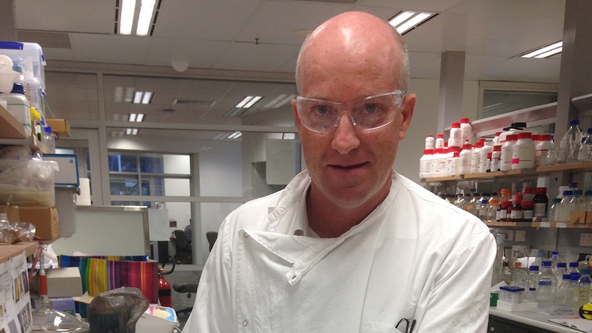 University of Queensland Professor Darren Martin holding the 'world's thinnest, strongest condom'