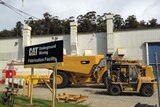 Machinery sits inside the fence at the Wivenhoe depot of Caterpillar in north-west Tasmania.