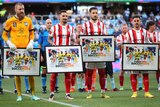 Four Socceroos players stand together during a presentation at an A-League Men match.