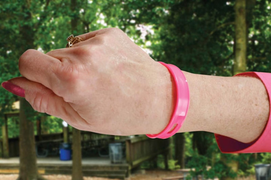 A girl wears a pink mosquito repelling wristband