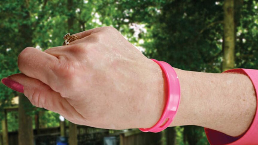 A girl wears a pink mosquito repelling wristband