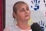 a woman speaking into a media microphone
