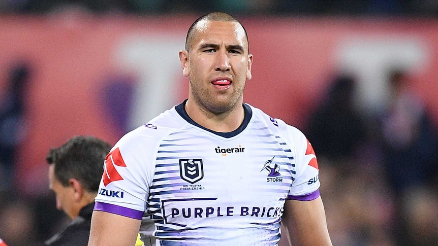 Nelson Asofa-Solomona walks off the NRL field as referee Gerard Sutton speaks to Melbourne Storm captain Cameron Smith.