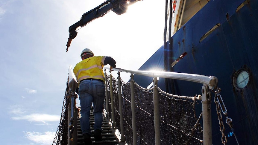 Man walks up ship ladder