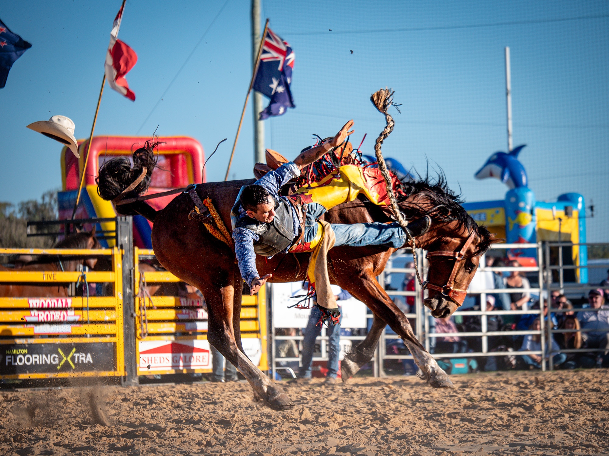 A man falls off a bucking bronco